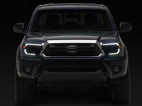 Raxiom 12-15 Toyota Tacoma Axial Series Switchback Projector Headlights- Black Housing- Clear Lens